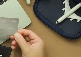 Hand holding card near laptop